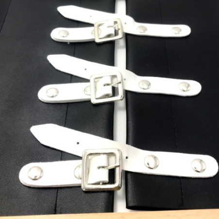 Cadre d'habillage boucles Montessori en skaï noir avec les boucles blanches, vu de détail de trois boucles ouvertes.