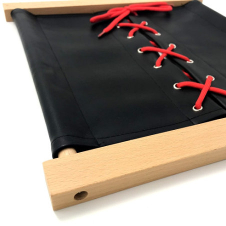 Cadre d'habillage  Montessori lacet de chaussure en skaï noir avec les lacets rouges, vu de trois quarts.
